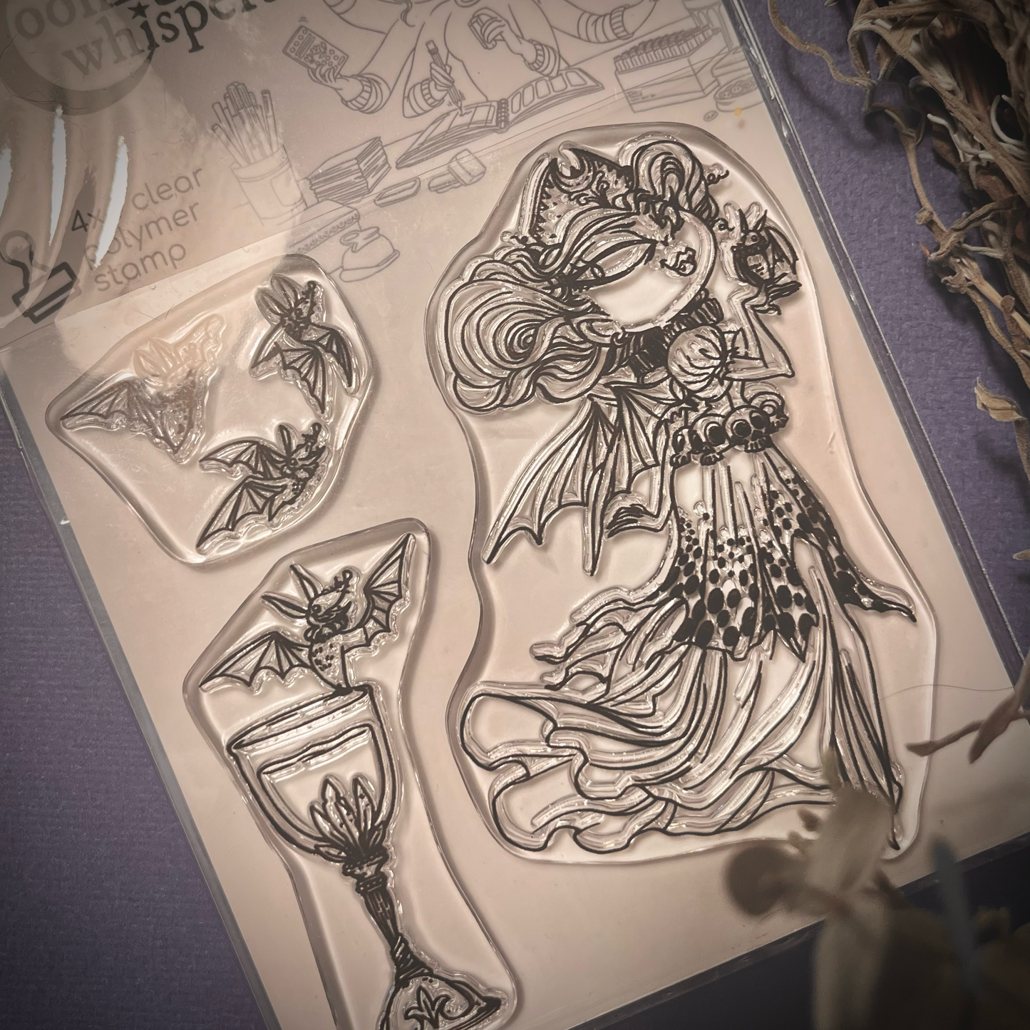 Clear stamp of a Vampire Queen holding a bat on her hand and floating. There are also accessory stamps of bats and a chalice.